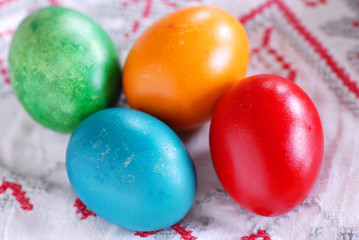 Four colorful easter eggs on linen tablecloth