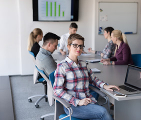 portrait of young business woman at office with team on meeting