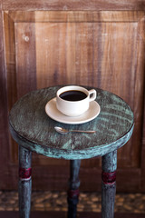 Black hot coffee on round vintage wooden table