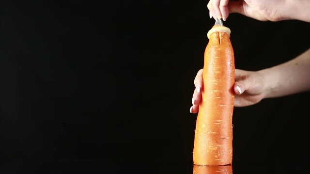 Orange carrot with a condom on a black background