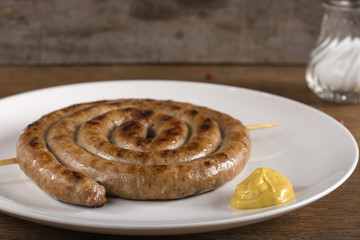 Spiral grilled sausage on plate