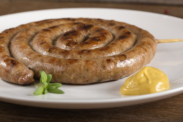 Spiral grilled sausage on plate