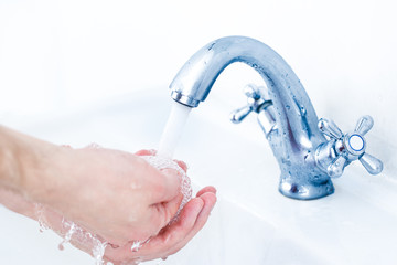 Washing hands under running water tap