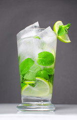 Mojito cocktail on a black background with a straw. Green mojito