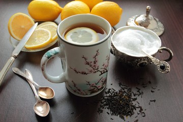 Obraz na płótnie Canvas Hot tea mug with lemon and sugar