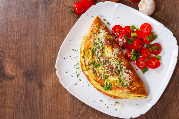 omelette with cheese and salad in a plate on wooden table - obrazy, fototapety, plakaty