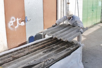 Trabajador mete fibrocemento en bolsa para amianto