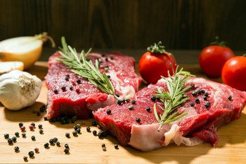 Raw beef steak on  wooden table with vegetables