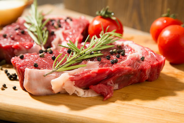 Raw beef steak on  wooden table with vegetables