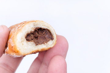 Hand holding chocolate homemade roll bun pastry