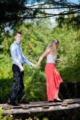 loving couple in the rural landscape. woman in a red dress and a man in a blue shirt