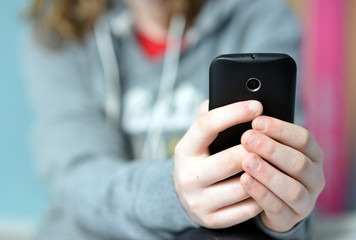 Teen holding mobile (cell) phone in hands