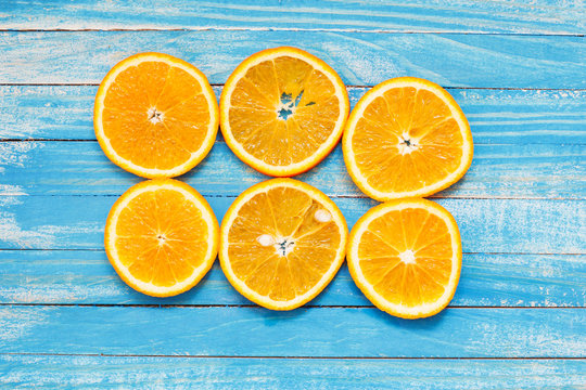 Slices of fresh orange on blue wooden table