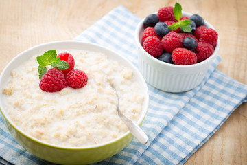 Oatmeal porridge in bowl with berries raspberries and blackberri