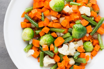 Fresh vegetables mix in a white bowl.