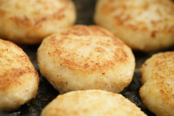 preparing fried fish cakes on pan, shallow focus
