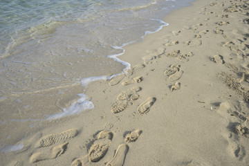 alone, fine sandy beach with footprints of people on its surface