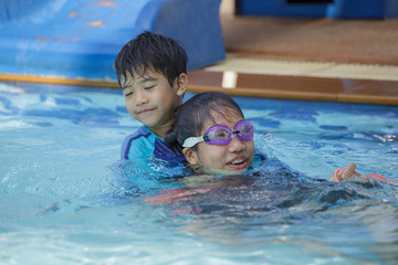 Happy Asian kids having fun at swimming pool