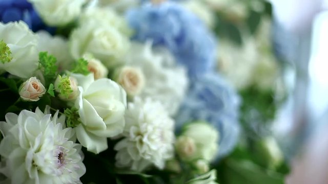 white and blue hydrangeas and roses in floral arrangements. the focus right to left and left to right. close up