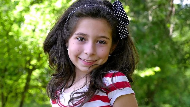 Slow motion portrait of a cute young girl smiling