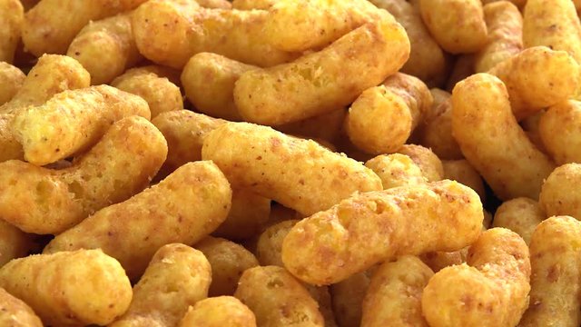 Rotating Peanut Puffs (seamless loopable; 4K footage) on wooden background