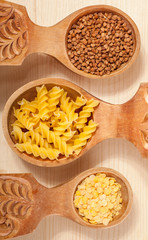 three wooden spoon with buckwheat, lentil and pasta fusilini