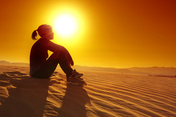 Fototapeta na wymiar sportswoman resting on top of a sand dune