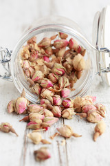 Dried rose buds spilling from a jar