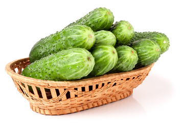 cucumbers in a wicker basket isolated on white background