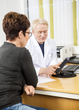 Doctor Showing Tablet Computer To Female Patient