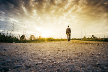 Man looking a country landscape at the sunset