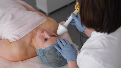 Face skin care treatment. Ultrasound cavitation anti-aging, rejuvenation, lifting procedure in medical cosmetology spa salon.