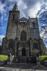 Dunfermline abbey facade, seen from the street. Image was shot at noon on a partial-cloudy day. The existance of dunfermline abbey can be traced back to the 11th century.