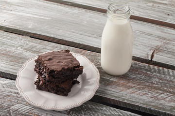 Decadent dark chocolate chip brownie with a milk jug on an antique plate