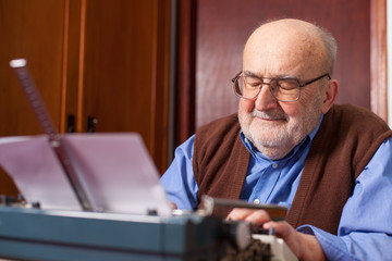 old man typing on a typewriter