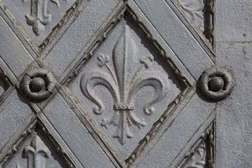 Metal ornamental door with cross and fleur de lis