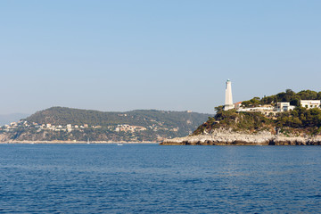 Color DSLR wide angle stock image of lighthouse and houses along the Mediterranean coast of the French Riviera near Nice, France. Horizontal with copy space for text
