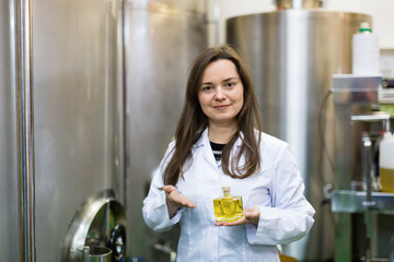 Portrait of smiling female engineer holding perfume oil bottle