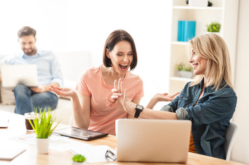 Attractive lady is boasting of her engagement at work