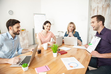 Cheerful creative team is discussing a project