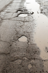 Large Pot Holes on a Rain Soaked Road