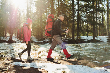 A group of tourists consisting of guys and girls going in the woods along the river