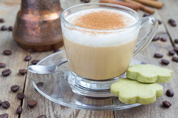 Coffee latte in glass cups with matcha cookies, on a wooden table