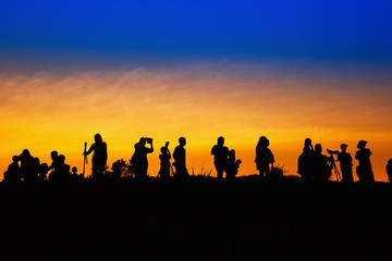 Fototapeta na wymiar Silhouette tourists and photographers with beautiful sunrise on