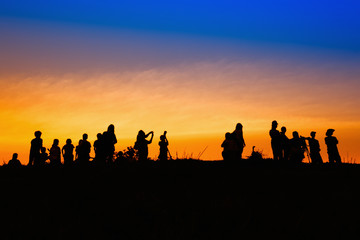 Fototapeta na wymiar Silhouette tourists and photographers with beautiful sunrise on