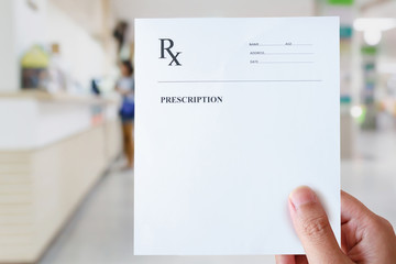 hand hold prescription paper with hospital background - obrazy, fototapety, plakaty