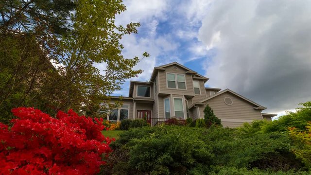 Time lapse of clouds over suburban residential home with blooming azaleas and plants spring season 4k uhd
