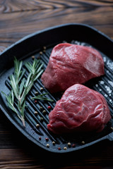 Raw fresh fillet mignon beefsteaks on a cast-iron grill, closeup
