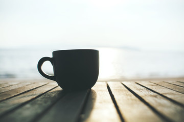 Cup of coffee on wood table in the morning