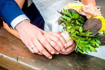 The bride and groom hold each other's hands
